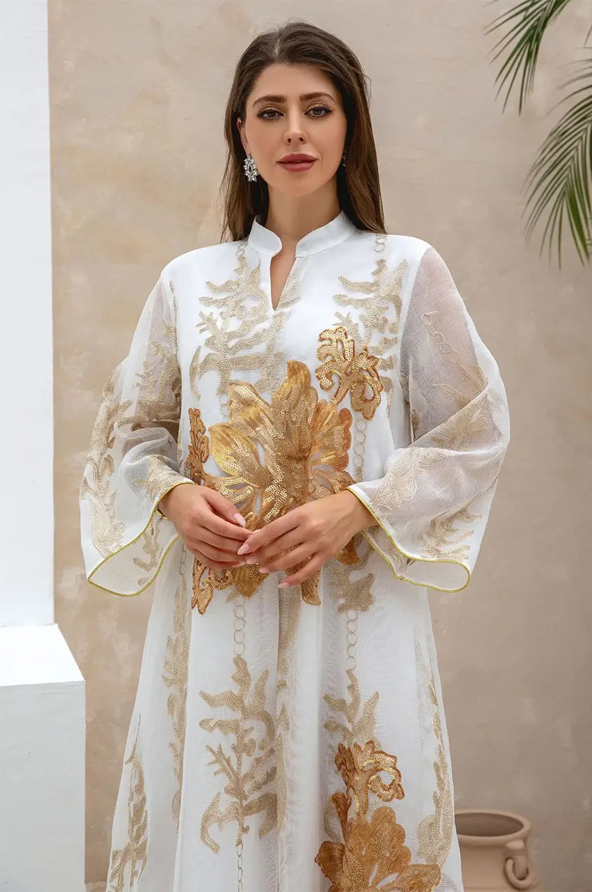 Close-up of the gold floral embroidery and V-neckline on the white Maliya flower kaftan.