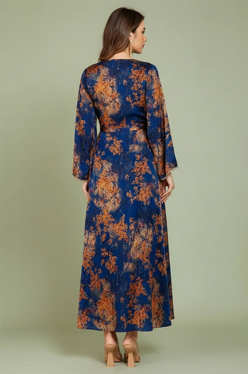 Rear view of the blue Noria fitted kaftan showing the floor-length drape and elegant foliage patterns.