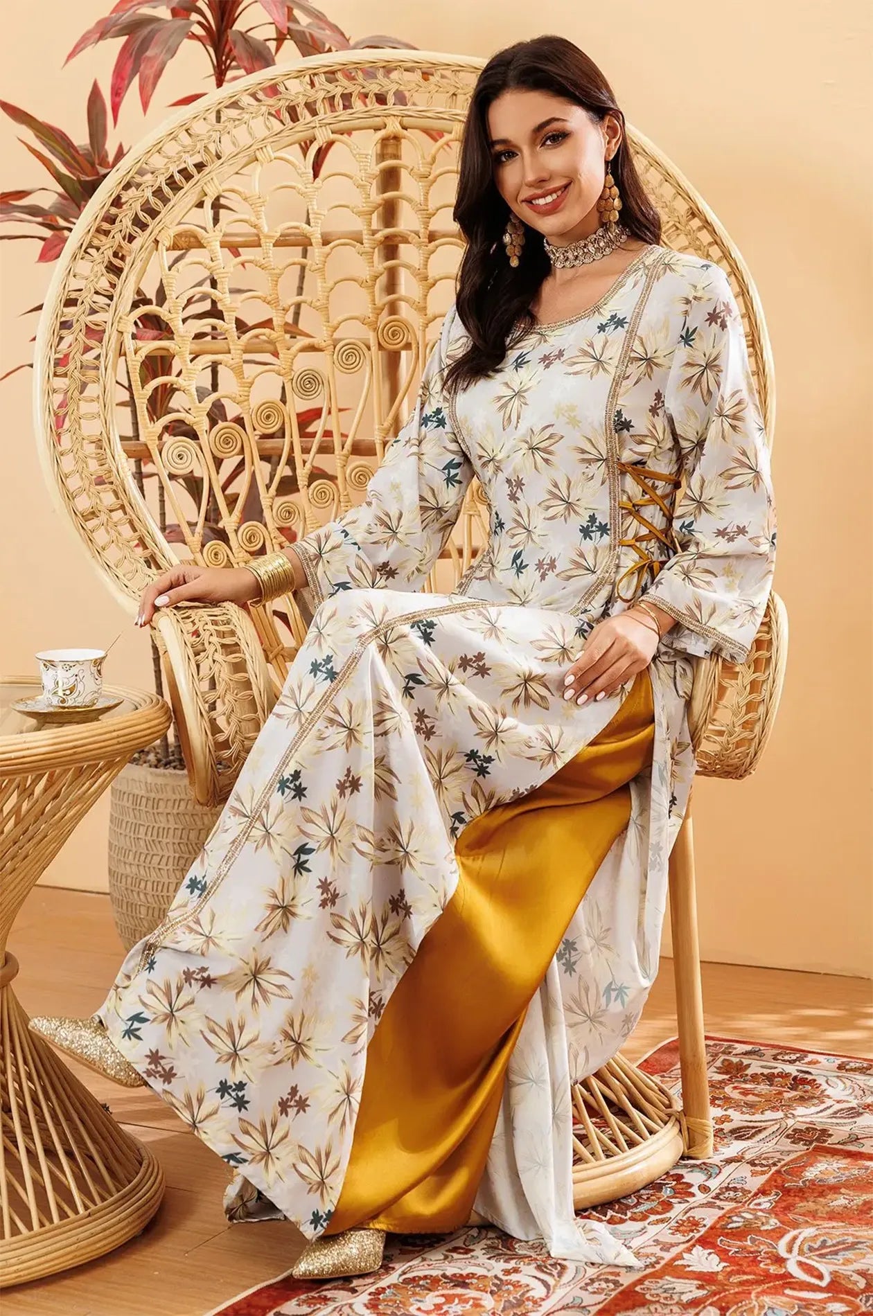 Model sitting in Nysria kaftan showing gold accessories and inner lining.