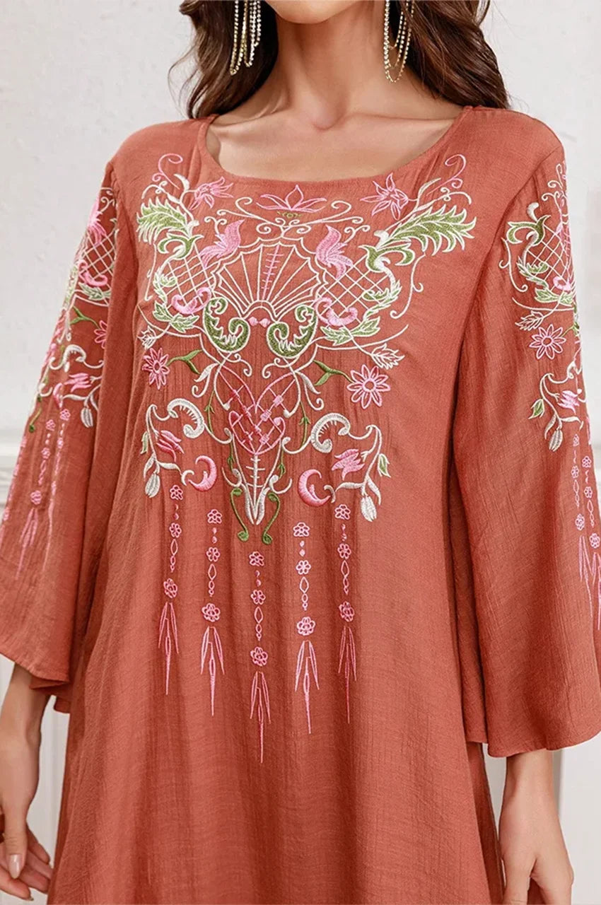 Macro detail shot of the pink and green floral embroidery on the chest.