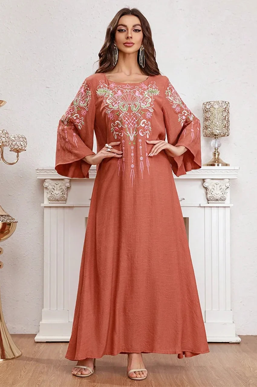 Close-up of model posing with hands on waist showing bell sleeve embroidery.