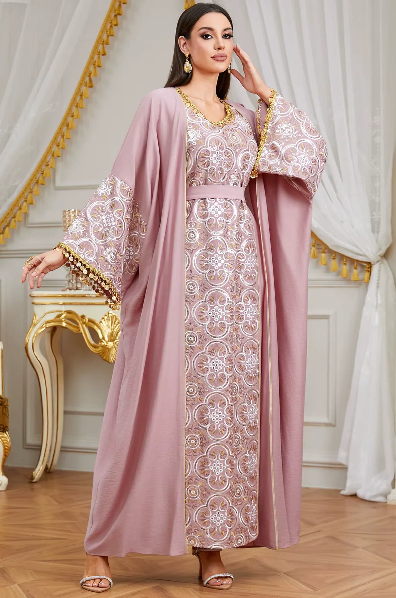 A sophisticated powder pink Novae crepe kaftan with silver and gold embroidery, featuring bell sleeves and tassel finishes.