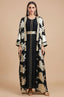 A professional studio shot of the Black Puppis kaftan luxe by Naylara with metallic gold botanical prints and floor-length drape.