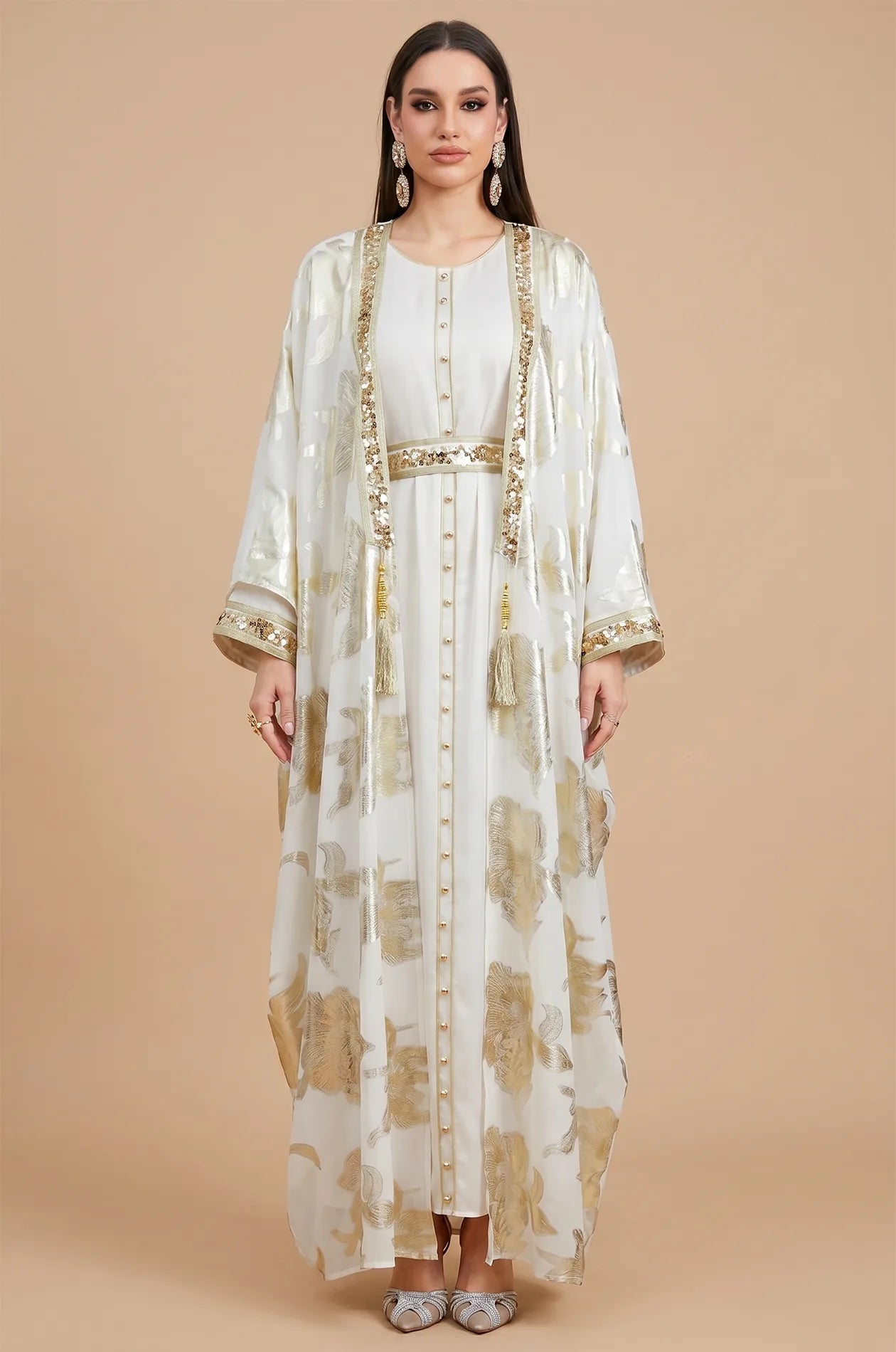 Frontal view of the Puppis white kaftan luxe with metallic gold botanical embroidery and a matching sequined belt.