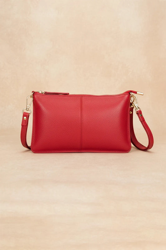 Front view of the vibrant red leather crossbody bag with adjustable strap and silver hardware.
