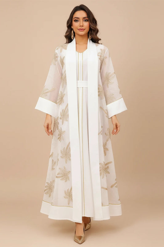 Front view of the SAELA white palm tree kaftan featuring gold botanical embroidery and a sheer organza overlay.