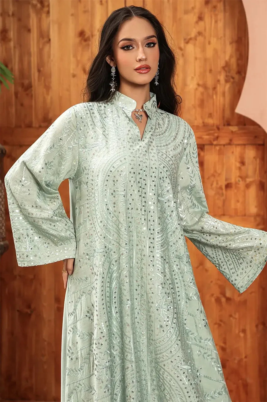 Fashion model posing in the sage green Maeli Kaftan highlighting the sleeve embroidery.