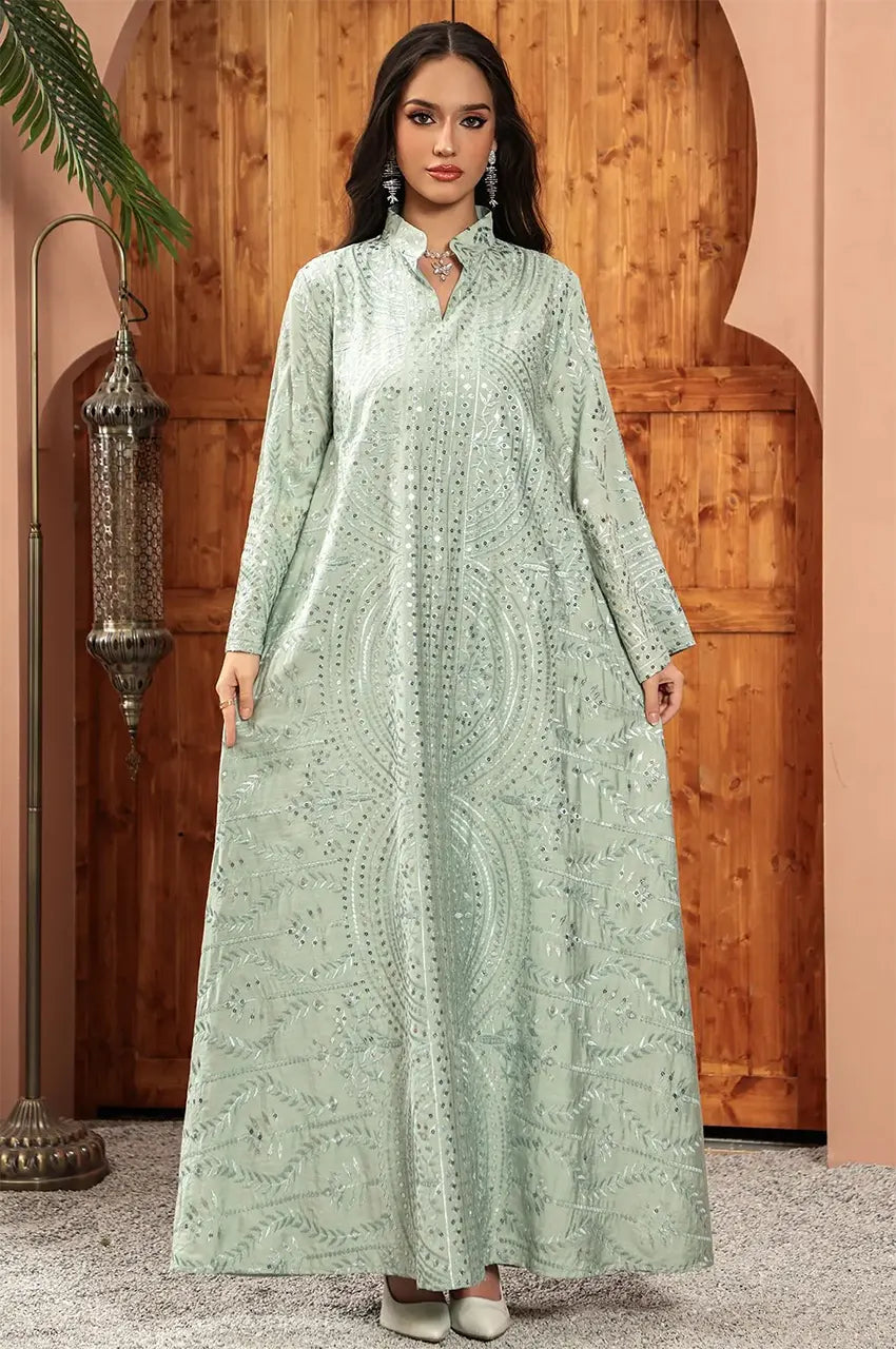 The Maeli Sage Green Kaftan displayed in a luxurious oriental setting with a traditional lantern.