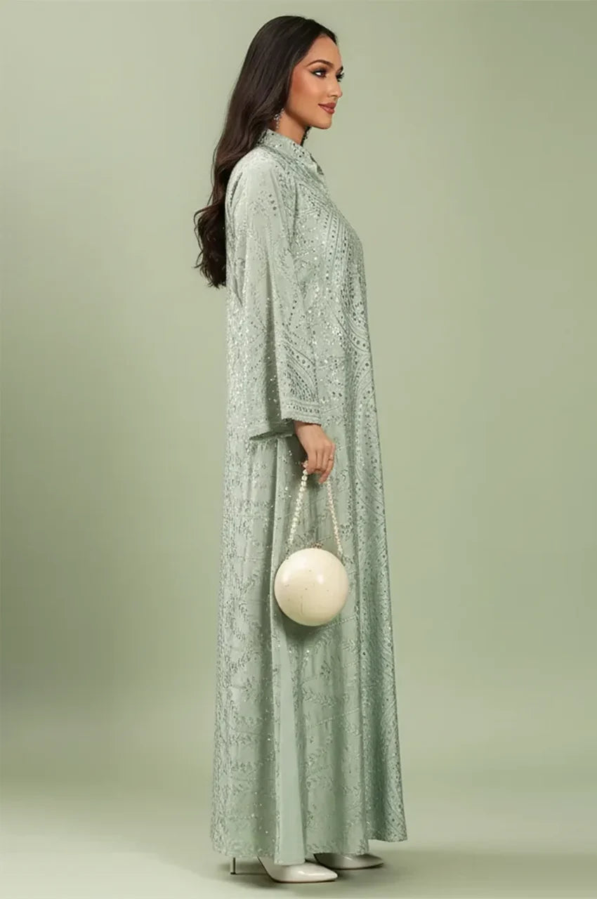 Side profile of the elegant Maeli Kaftan showcasing the flow of the sage green fabric.