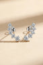 Front view of silver ear climber earrings with 7 graduated cubic moissanite stones on beige background.