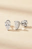 Front view of silver pear-shaped diamond simulant earrings on beige texture.
