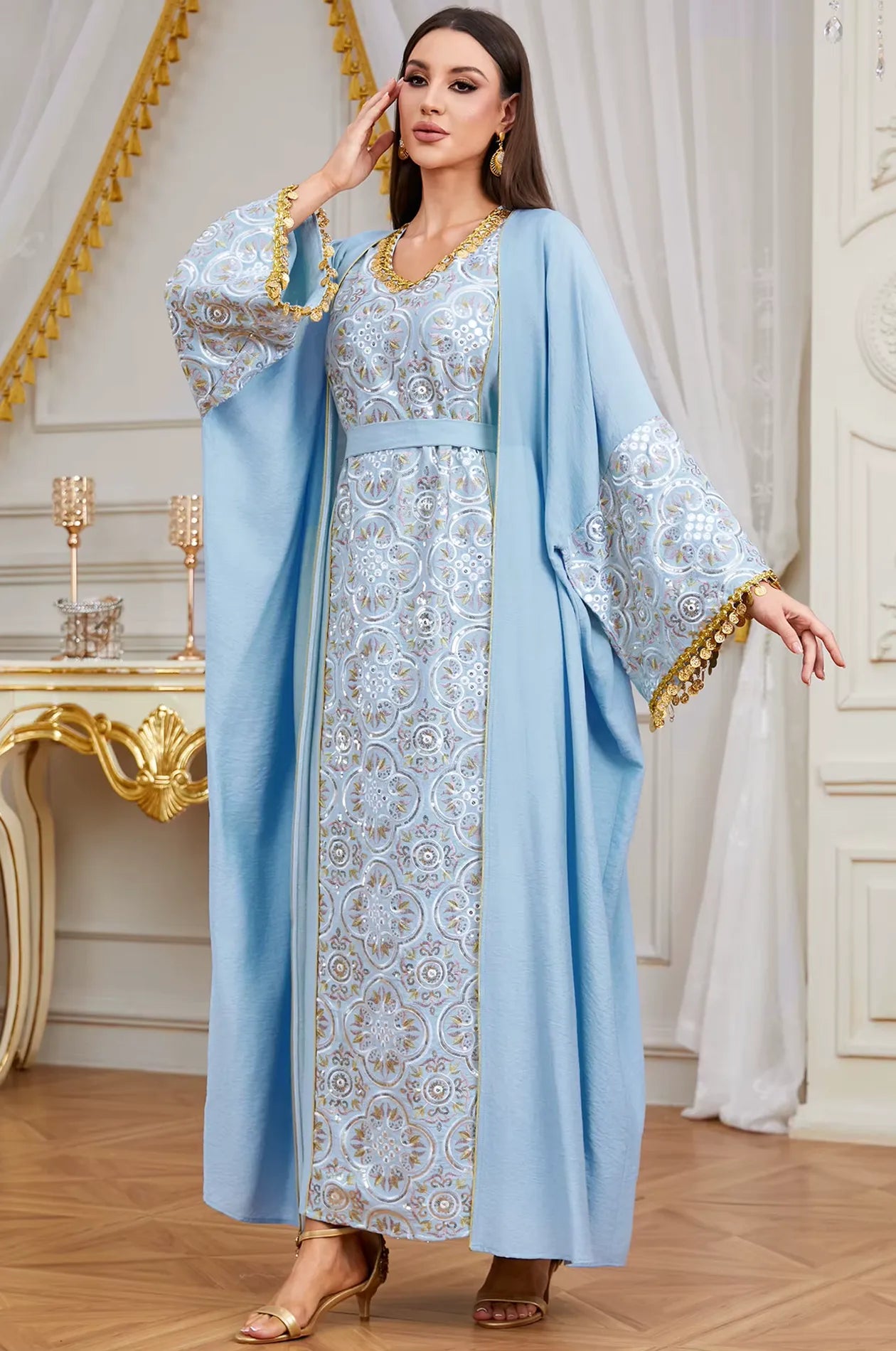 Sophisticated lifestyle shot of the sky blue Novae crepe kaftan with handcrafted gold tassel finishes.