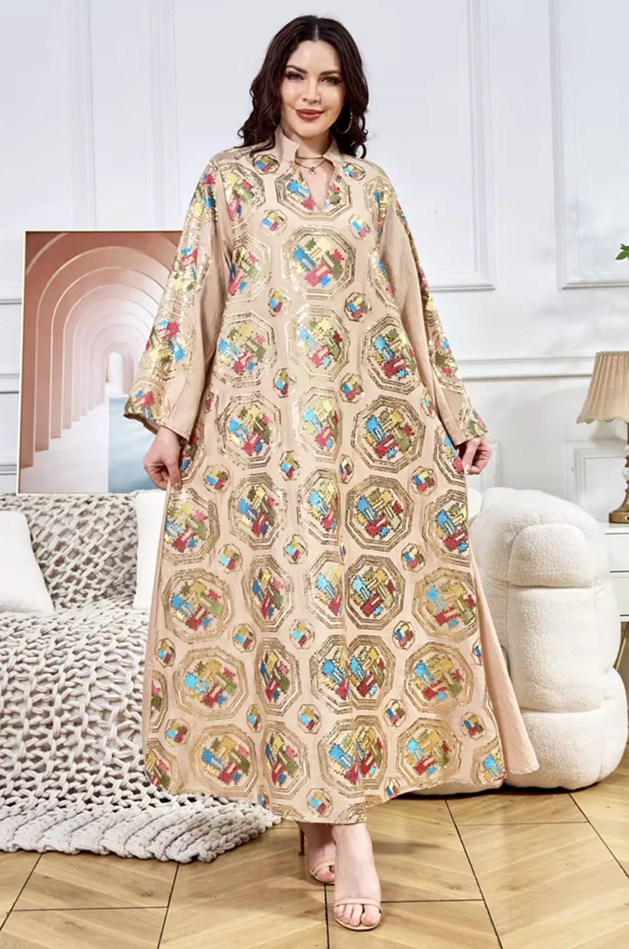 Dynamic fashion shot of the Sorin beige kaftan with a mandarin collar and shimmering gold sequin details.