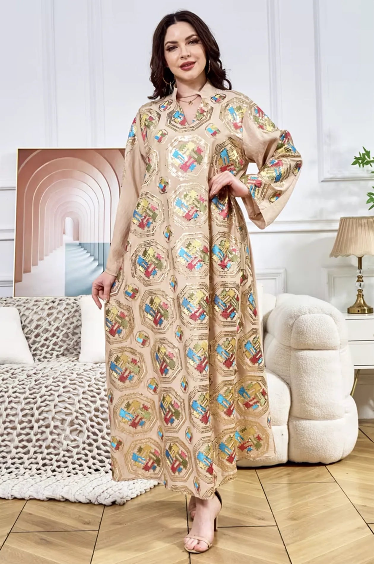 Model posing in the Sorin beige sequin kaftan with a mandarin collar in a sophisticated interior setting.