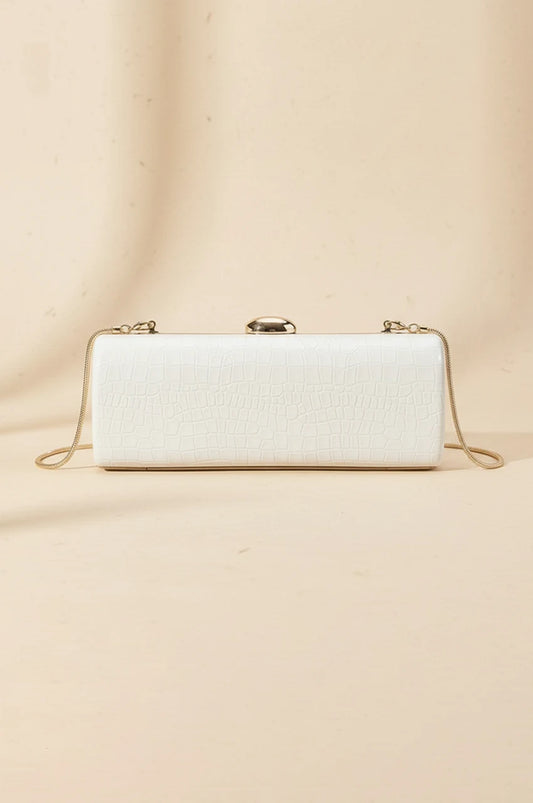 Front view of white patent leather cylinder evening bag with gold clasp and chain attachment points.
