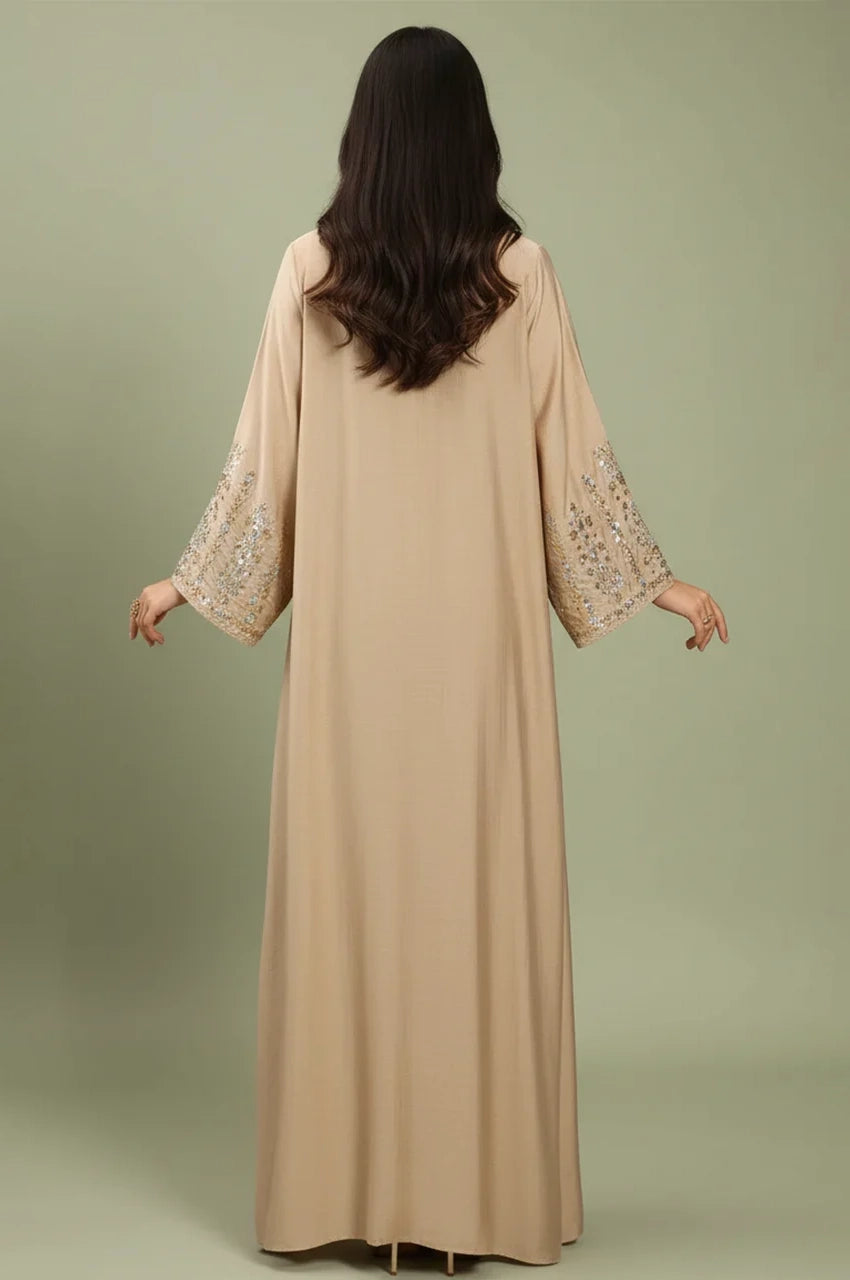 Back view of the Zahia beige Saudi kaftan showing fluid drape and embroidered sleeves.