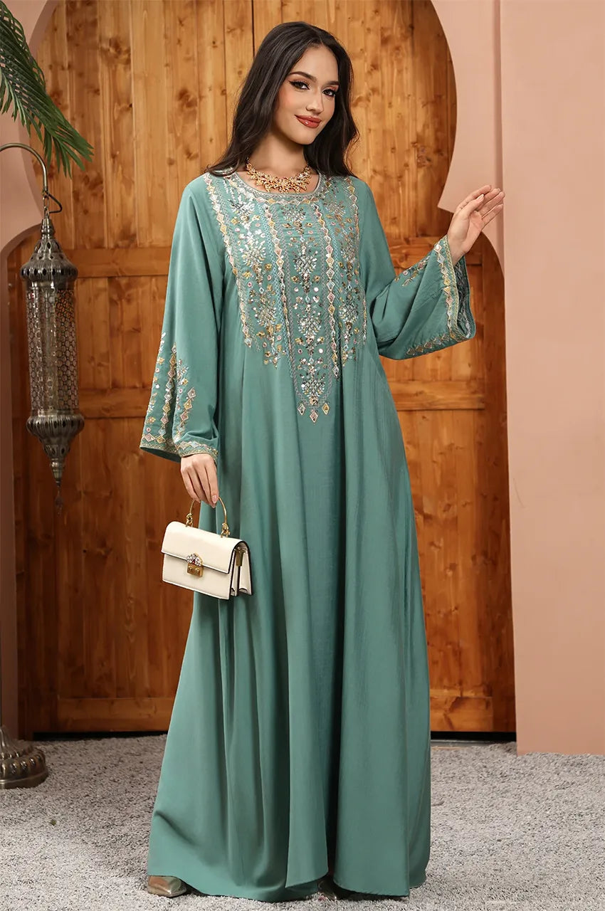 Elegant pose featuring the Zahia Green Saudi Kaftan with artisan geometric thread-work.