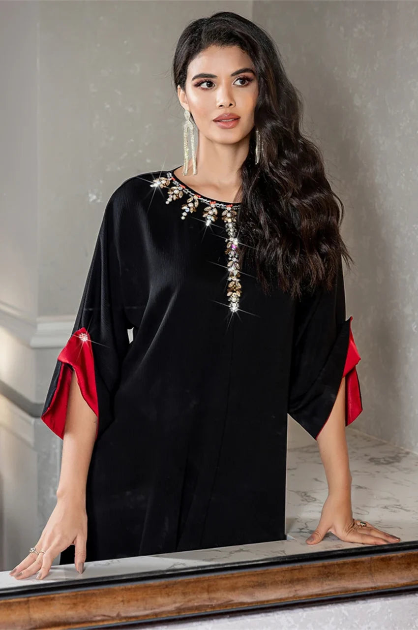 Reflection pose of model in Adara black satin kaftan