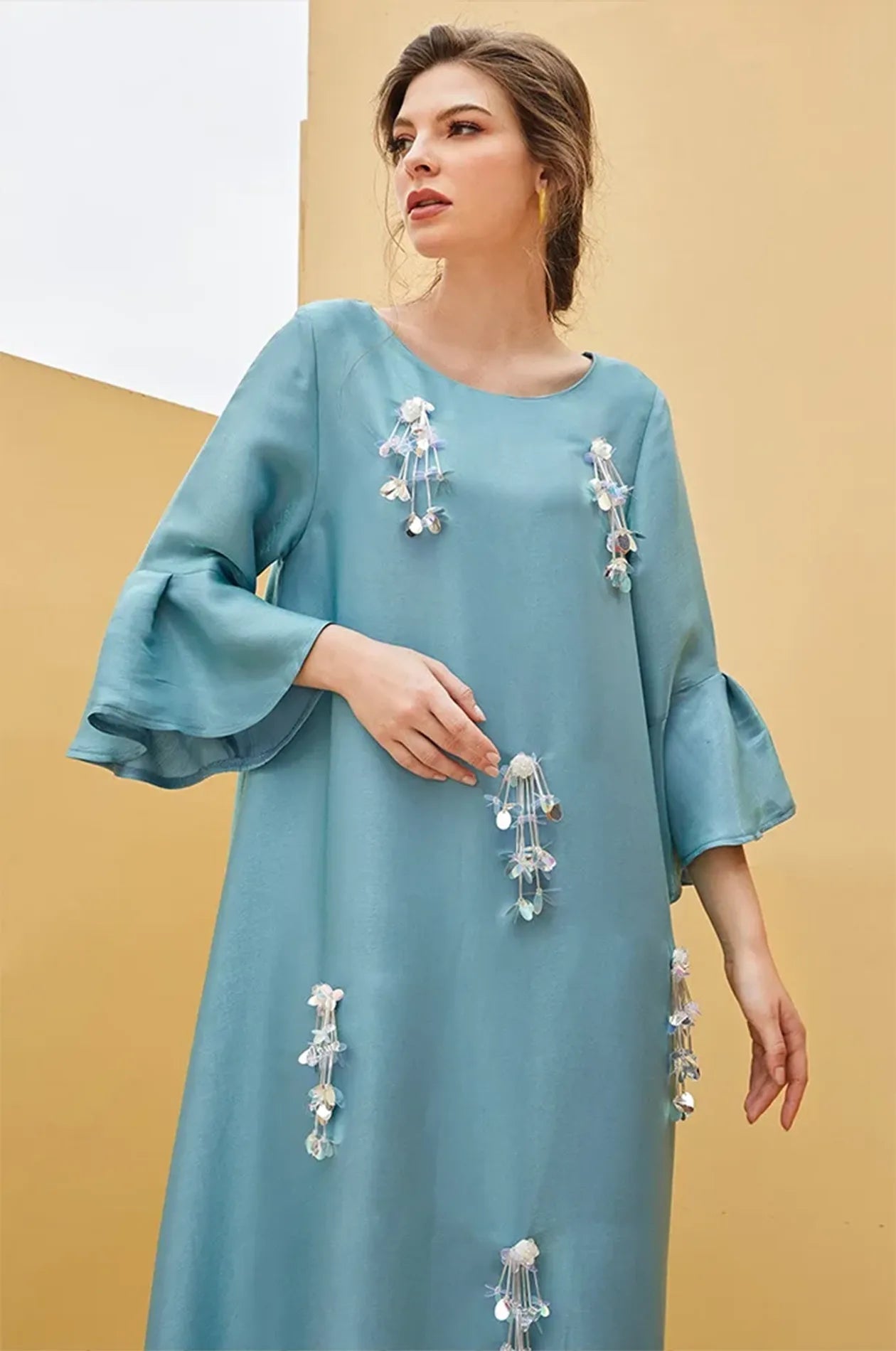 Close-up of 3D floral sequins and tassels on the Alima kaftan.