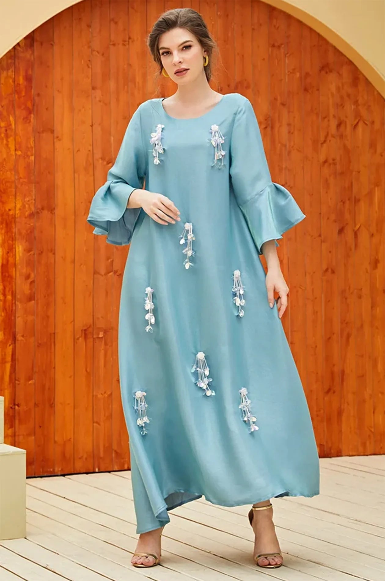 Model wearing the Alima aqua blue kaftan in a stylish outdoor setting.