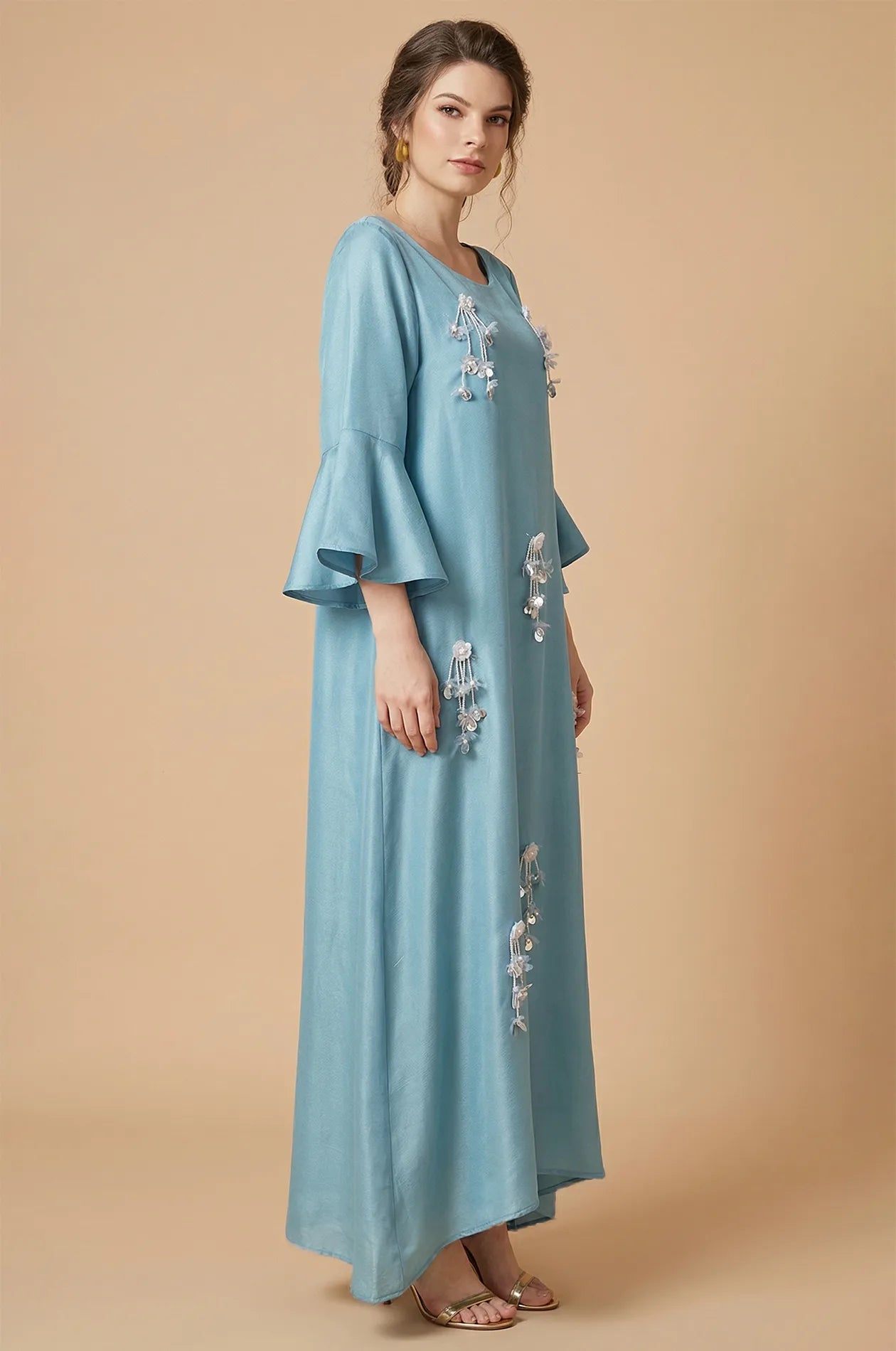 Side profile of Alima kaftan showing ruffle sleeves and flowing fabric.