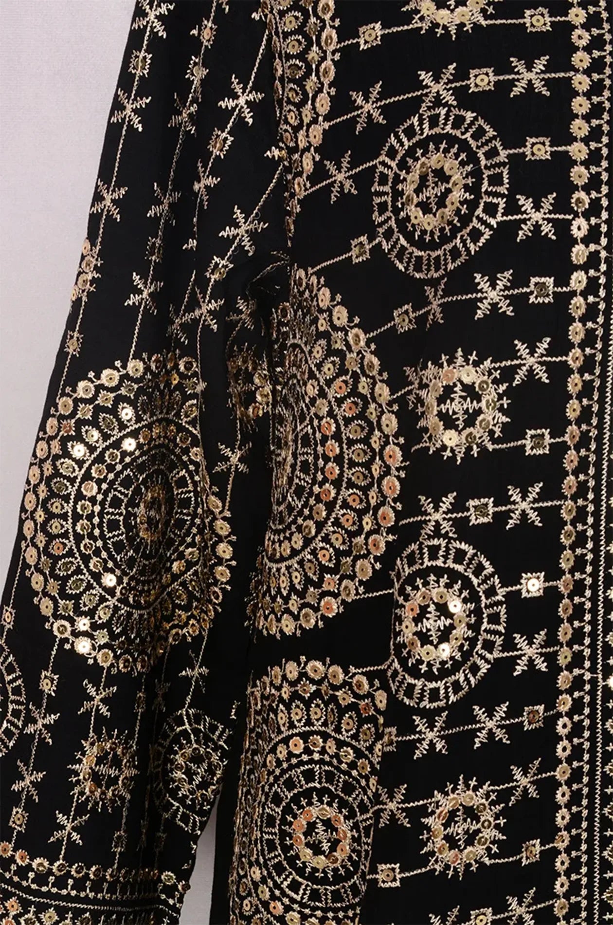 Close-up texture shot of the premium black fabric with intricate gold and silver mirror embroidery.