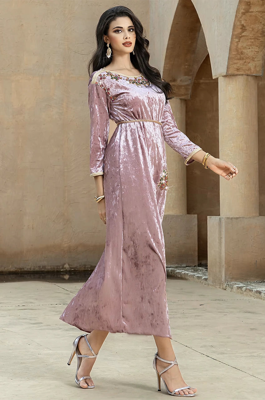 Walking pose wearing the pink velvet Pakistani kaftan Amina with soft drape