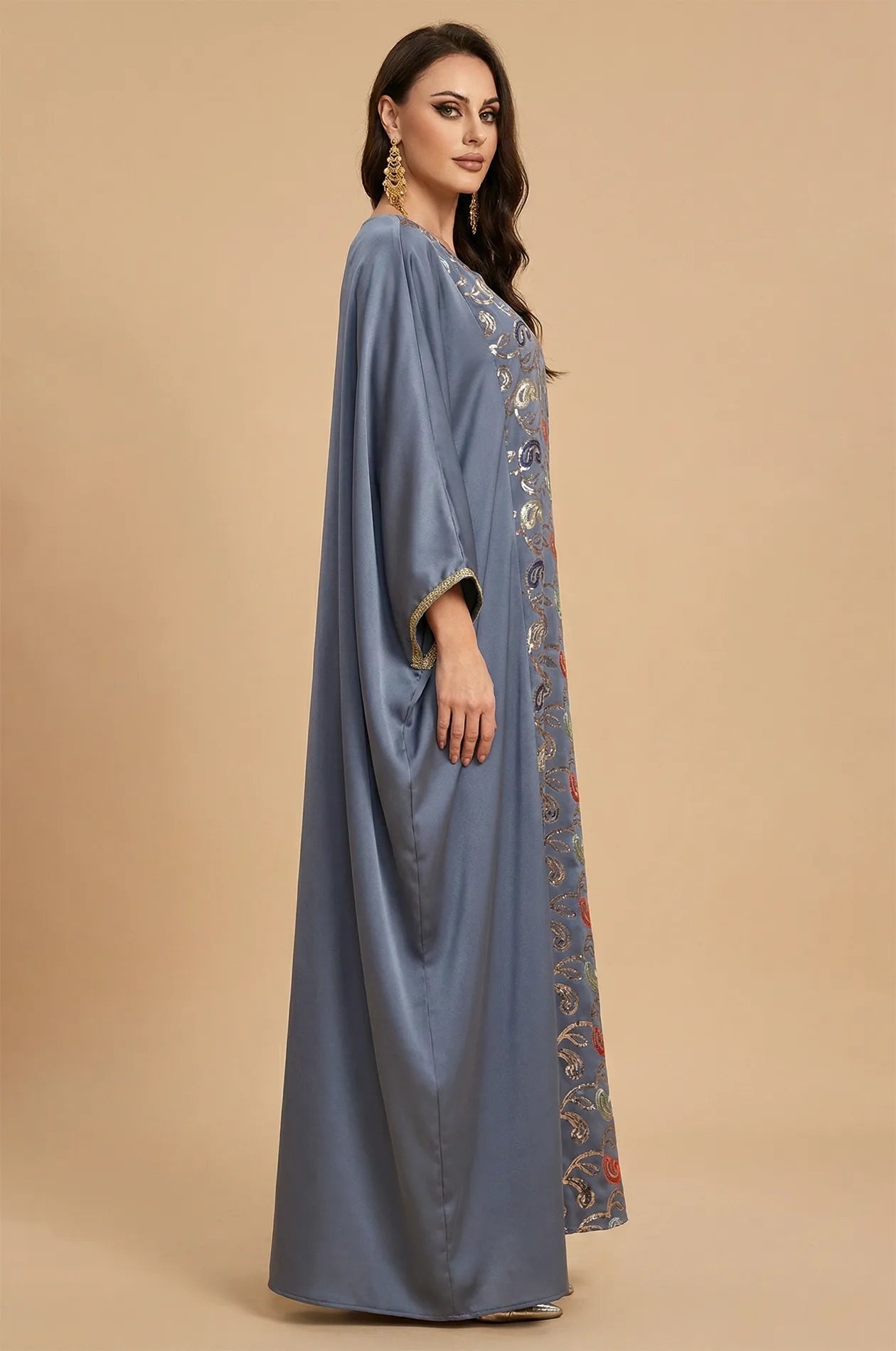 Side view of the Amiri gray farasha kaftan showing the elegant flow of the satin fabric and gold-trimmed sleeves.