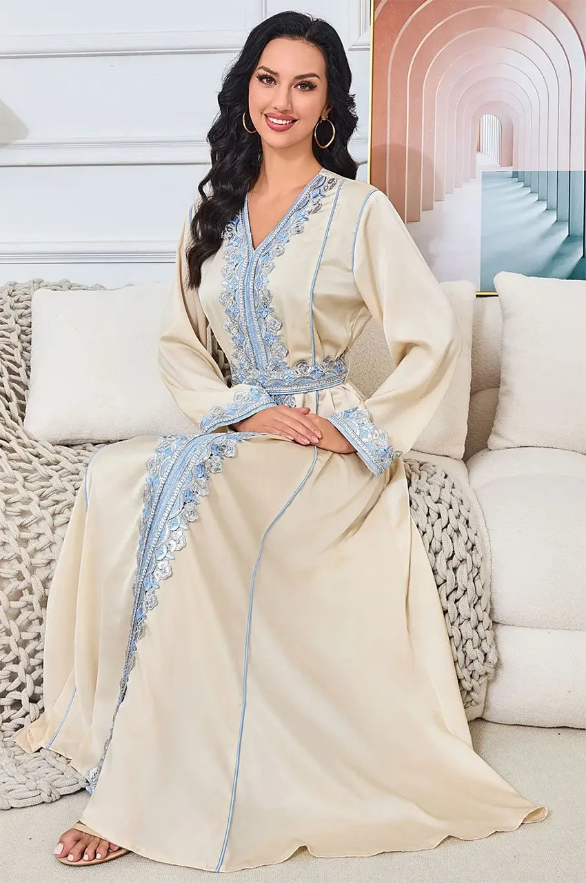 Ayana long satin kaftan styled in a seated position showing embroidery detail.