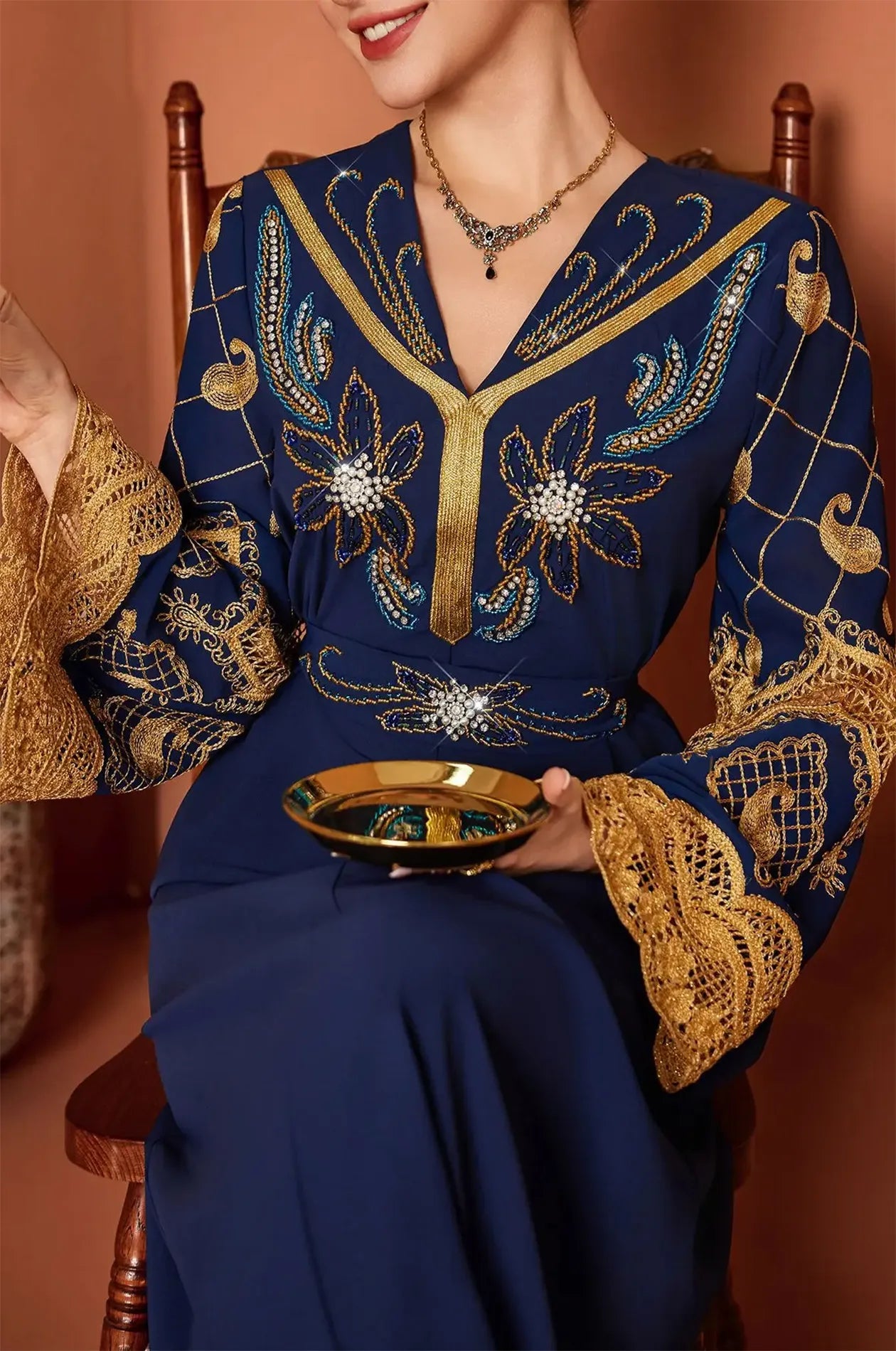 Macro shot of the high-quality gold thread and crystal accents on the waist and chest.