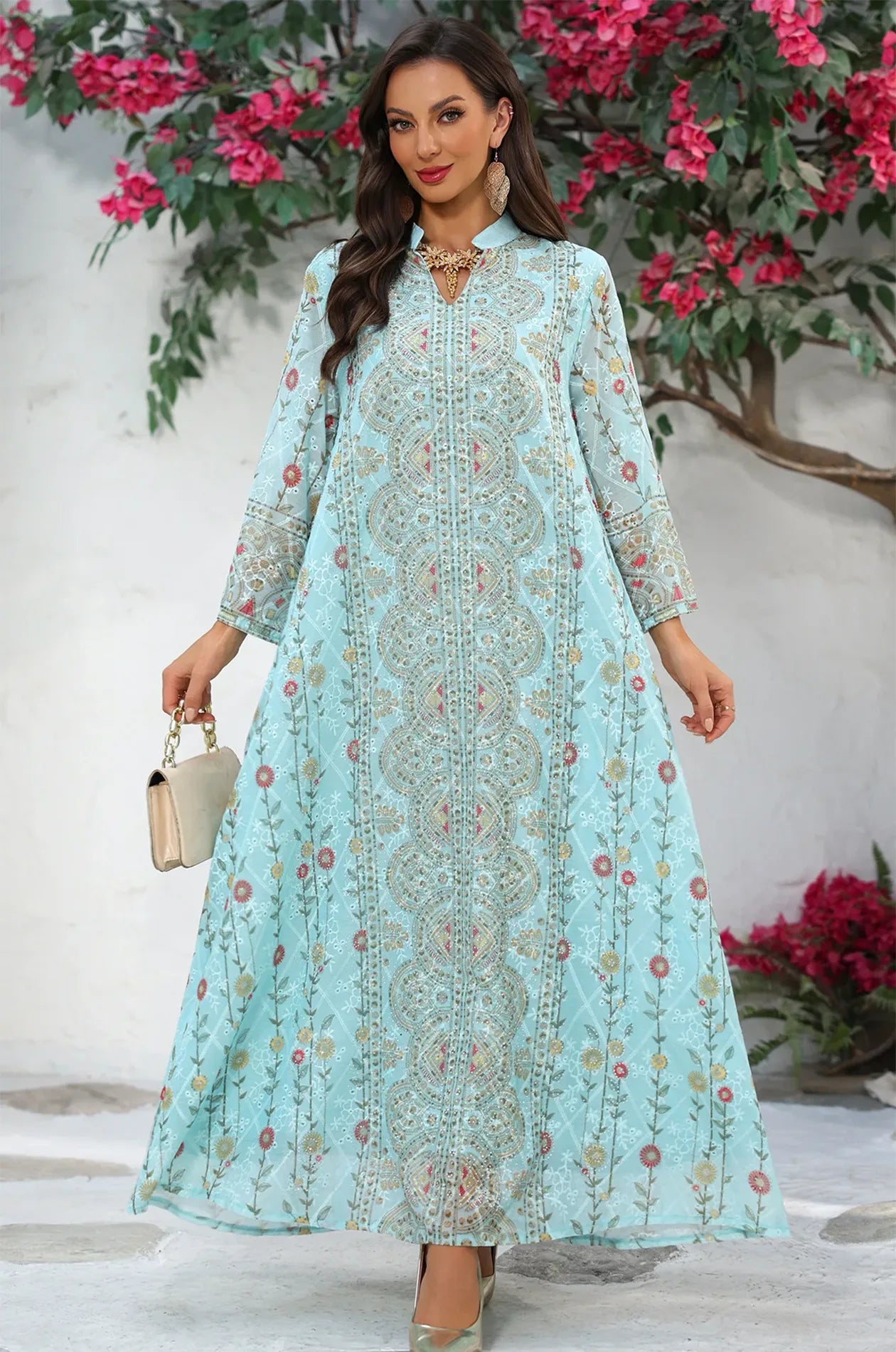 Elegant pose in the Azari mint green chiffon kaftan maxi dress featuring ornate floral motifs against a decorative background.