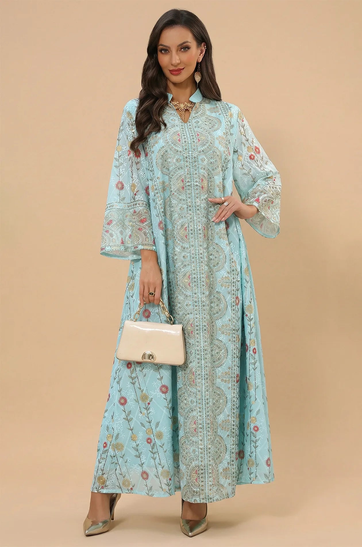 Front view of the Azari mint green chiffon kaftan maxi dress featuring elegant bell sleeves and a beige clutch bag.