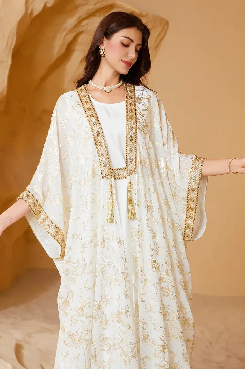Close-up of the jewel neckline with heavy gold braid embellishment on the white long open kaftan.