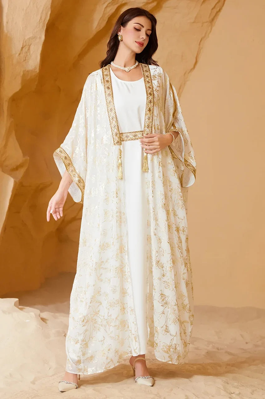 Detail of the wide butterfly sleeves and gold metallic trim on the AZIRI white long open kaftan.