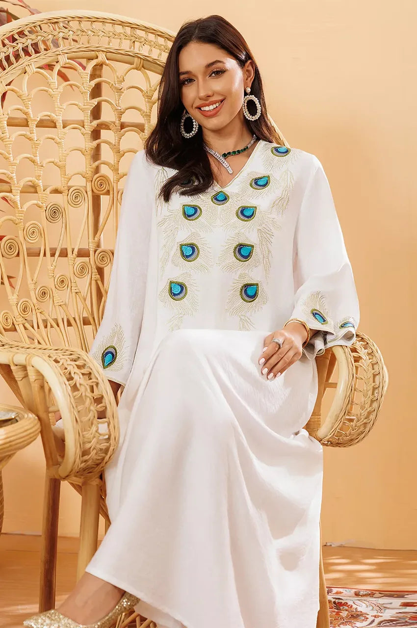 Seated woman in Azura white embroidered peacock kaftan