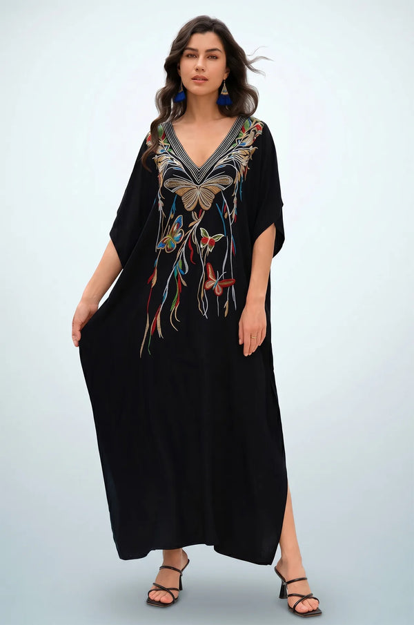 Woman holding black butterfly embroidered kaftan showing relaxed silhouette