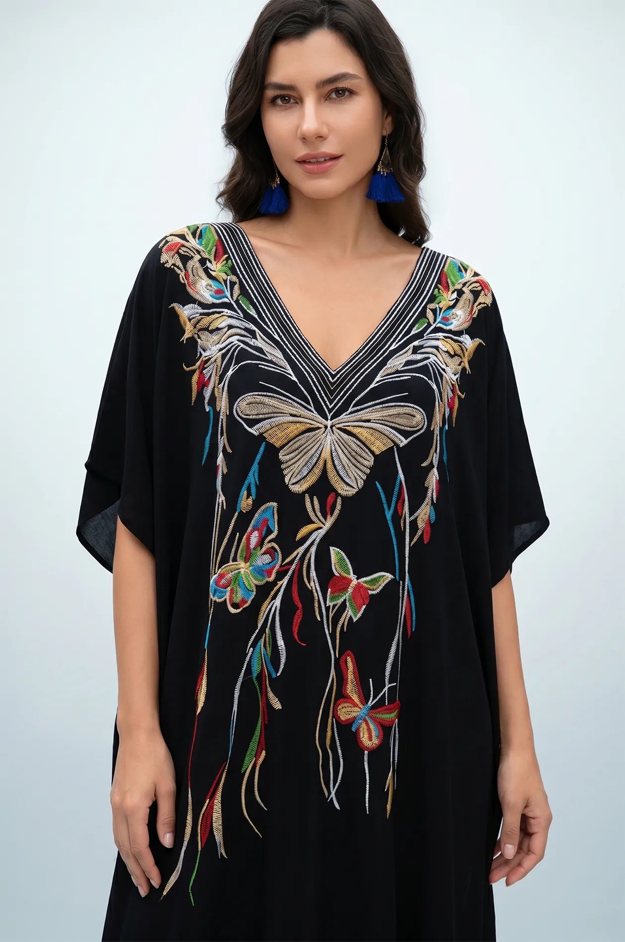 Front detail of black kaftan with gold butterfly embroidery and V-neckline