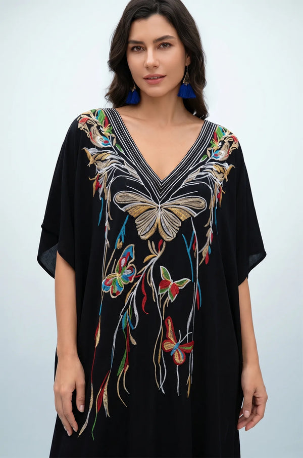 Front detail of black kaftan with gold butterfly embroidery and V-neckline