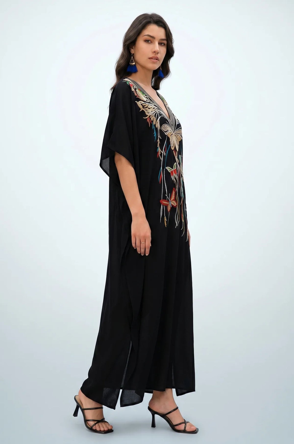 Side profile of black embroidered kaftan showing flowing drape
