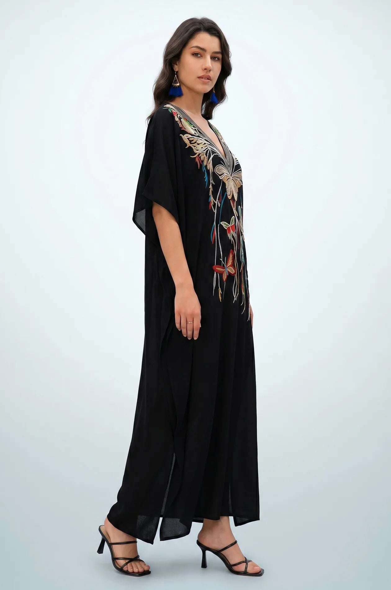 Side profile of black embroidered kaftan showing flowing drape