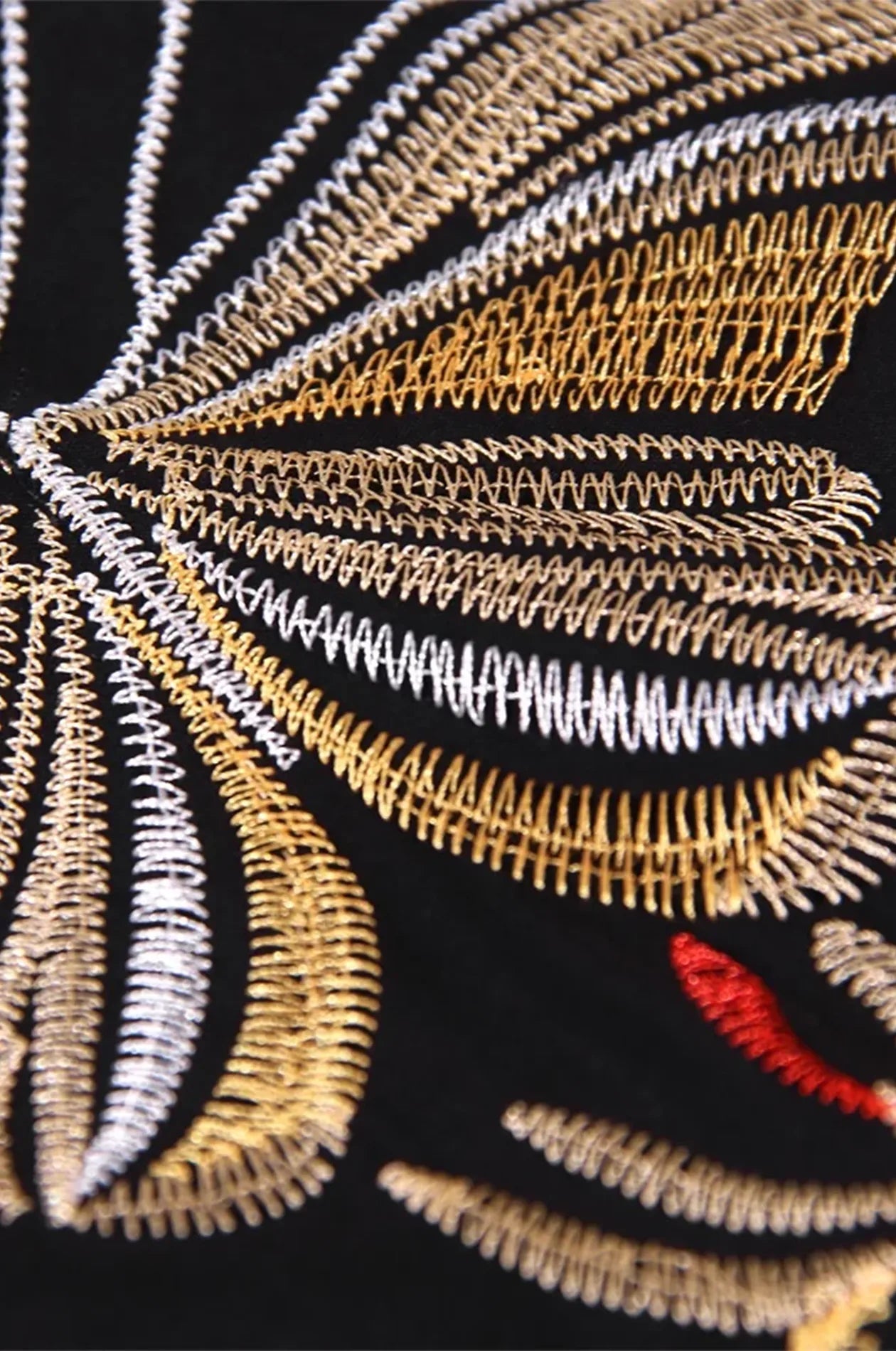 Macro close-up of metallic gold and silver butterfly thread embroidery