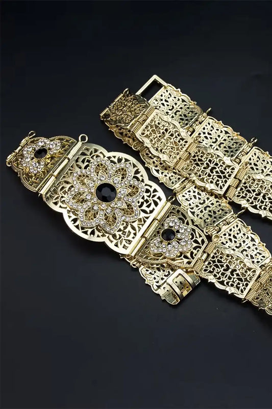 Angled view of the gold belt showing the black crystal center and hinged plates.