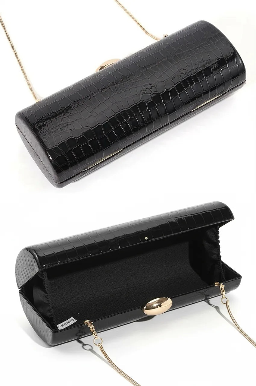 Open view of the black crocodile clutch revealing the black fabric lining and storage capacity.