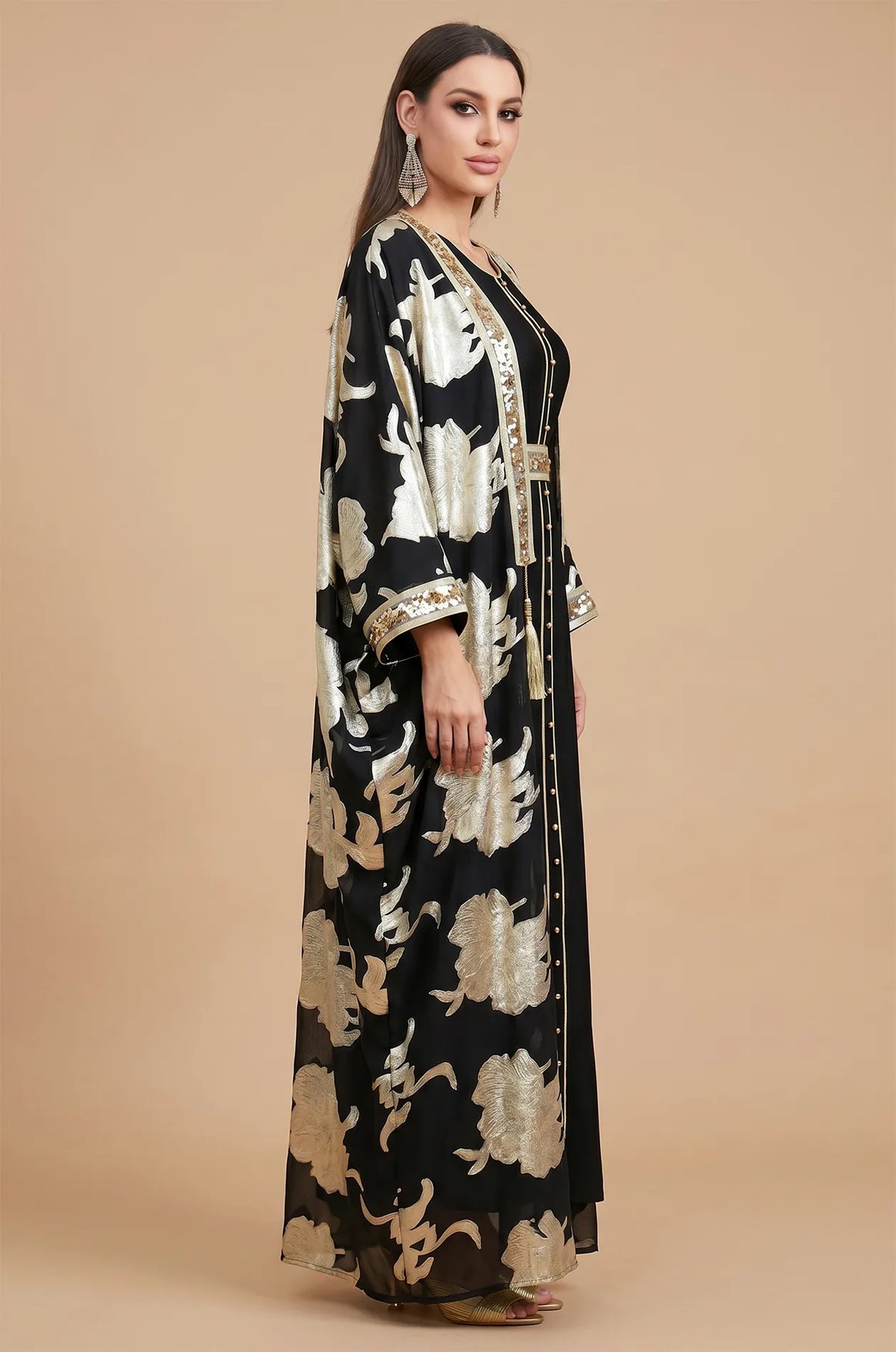 A side profile view of the Black Puppis kaftan luxe highlighting the elegant butterfly sleeves and shimmering gold sequin trim.