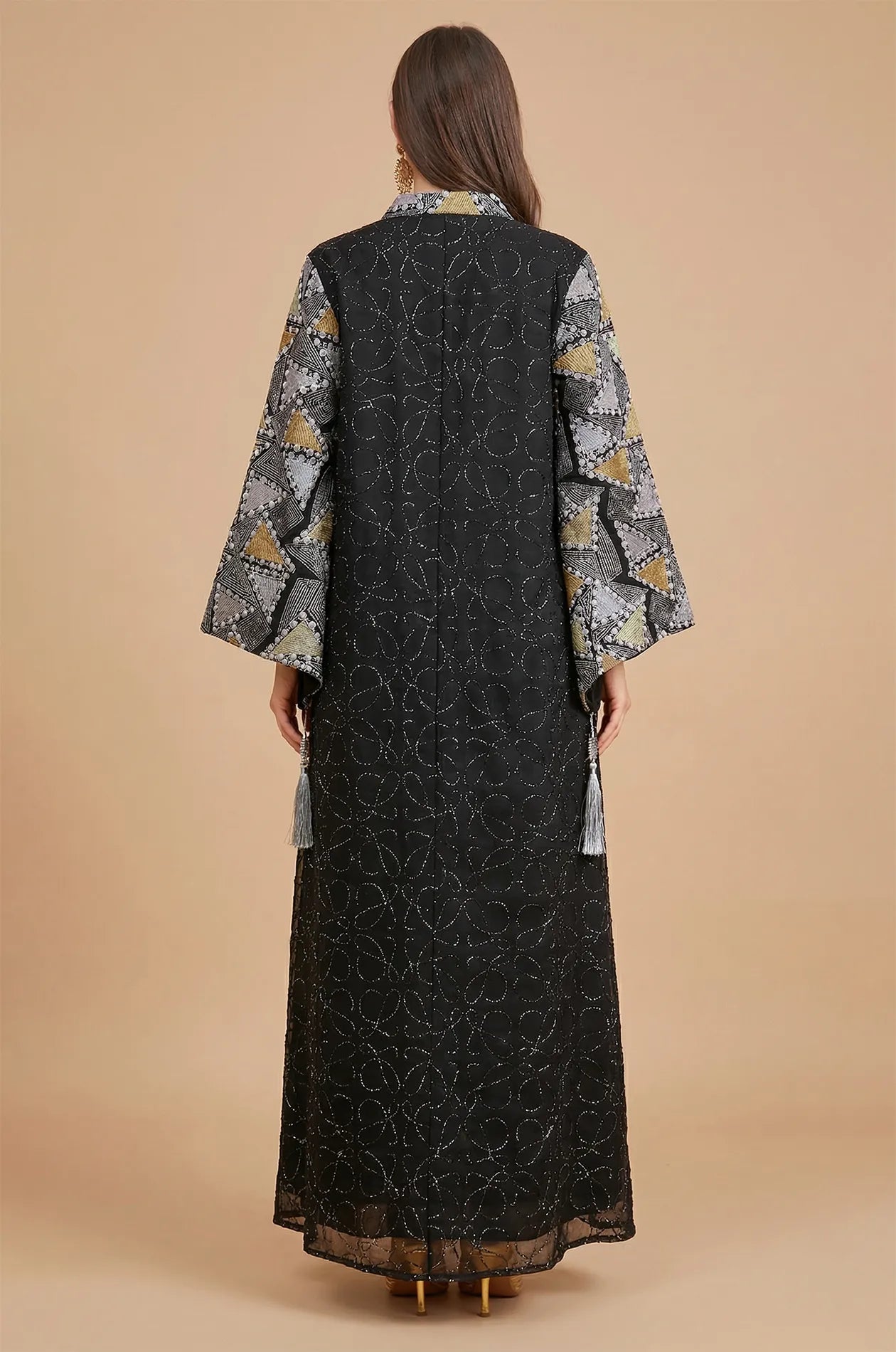 Back view of the Black Kaliera kaftan showing the modest floor-length silhouette and elegant all-over scrollwork embroidery.