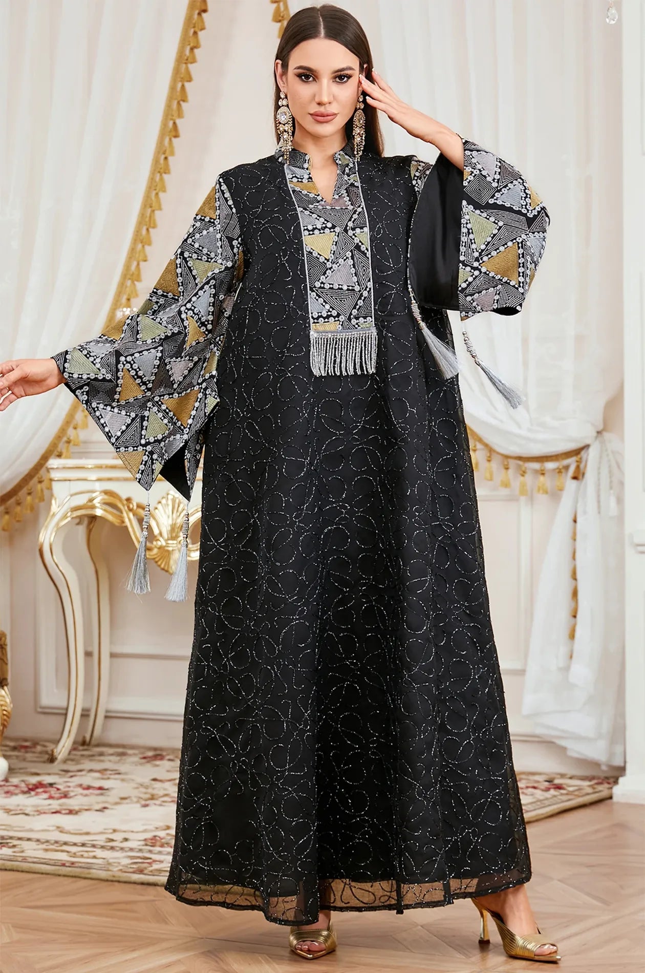Detailed view of the expansive bell sleeves on the Black Kaliera geometric kaftan, showing the contrast of gold and noir fabrics.