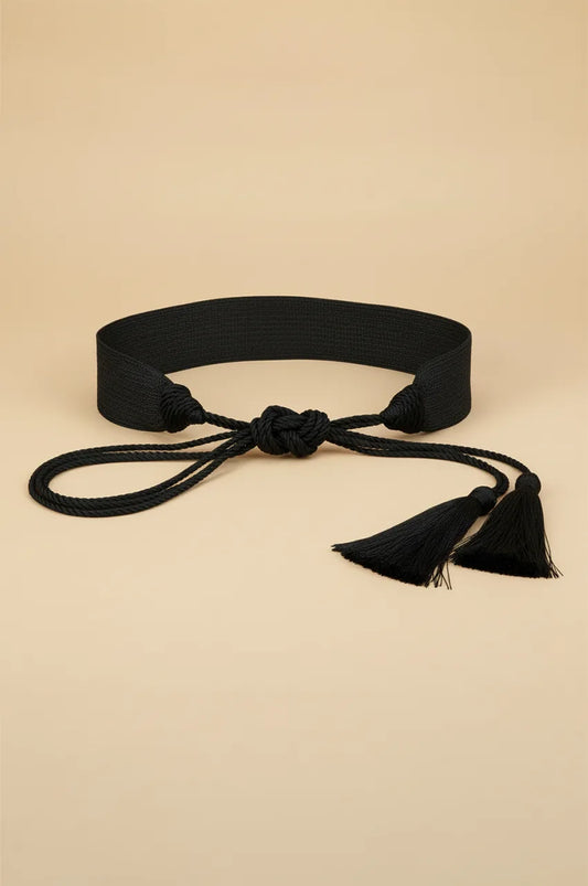 Front view of the black woven sash belt with rope ties centered on a beige background.