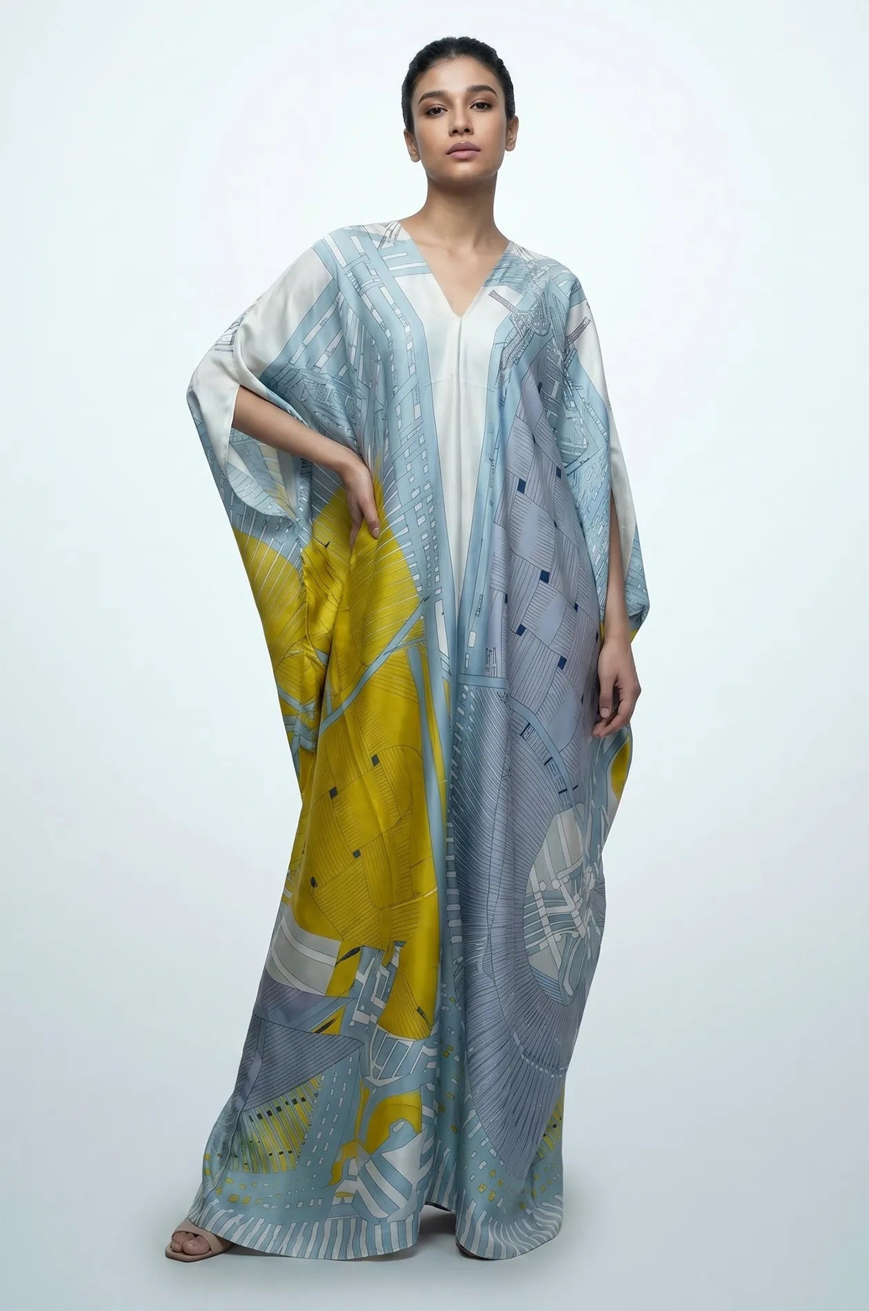 Woman in sky blue silk kaftan with kimono sleeves and yellow accent print