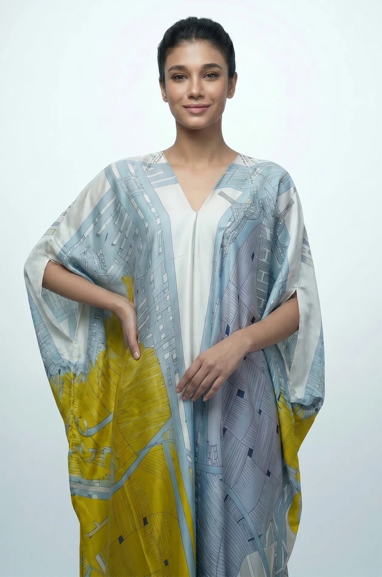 Woman wearing sky blue Lupis silk kaftan front detail with V-neckline and abstract print