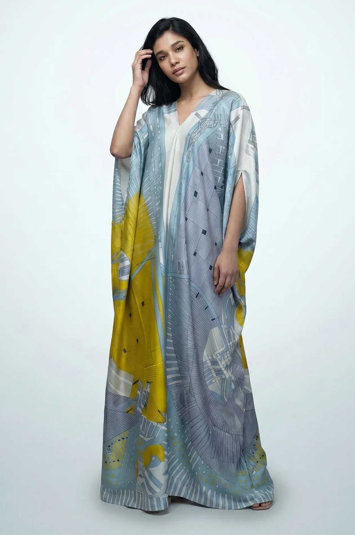 Blue boho beach kaftan with model adjusting hair showing fluid silk maxi